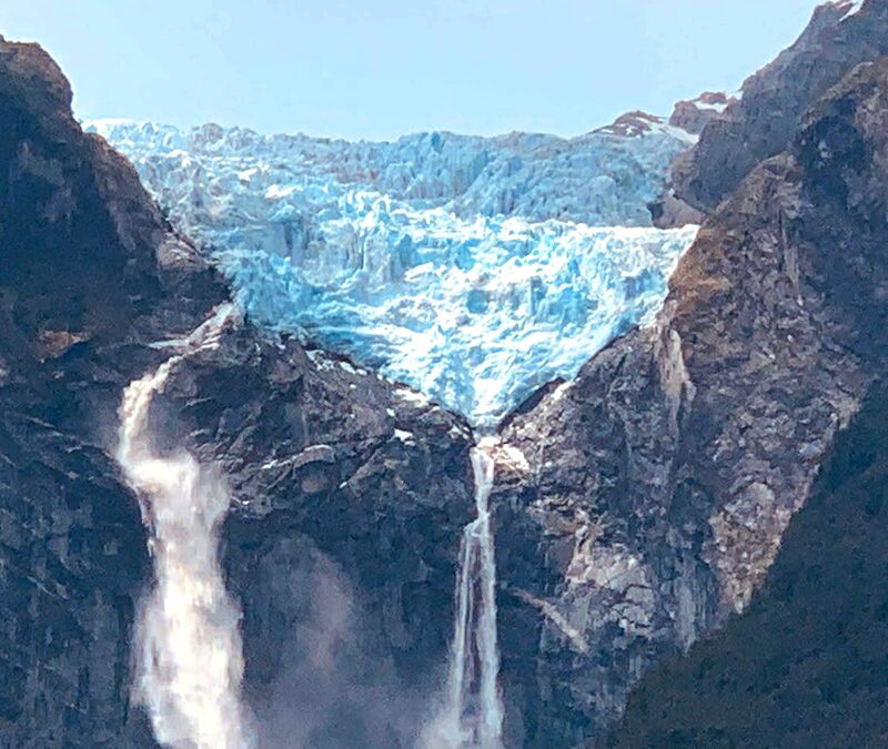 The stunning blue glacier and tall waterfall at Queulat National Park in Aysen, Patagonia