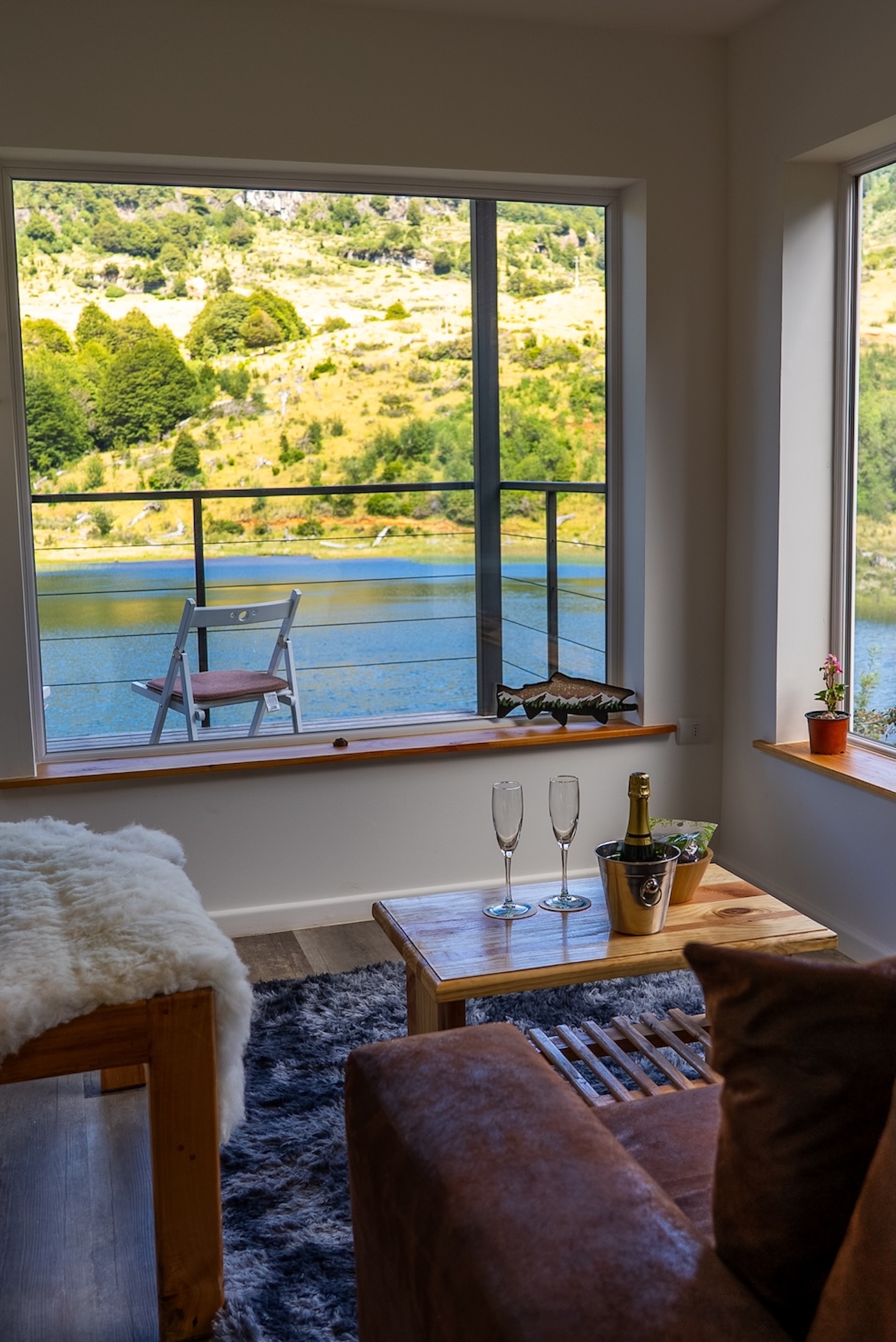 Champagne chills on a coffee table in a seating nook overlooking a placid outdoor landscape