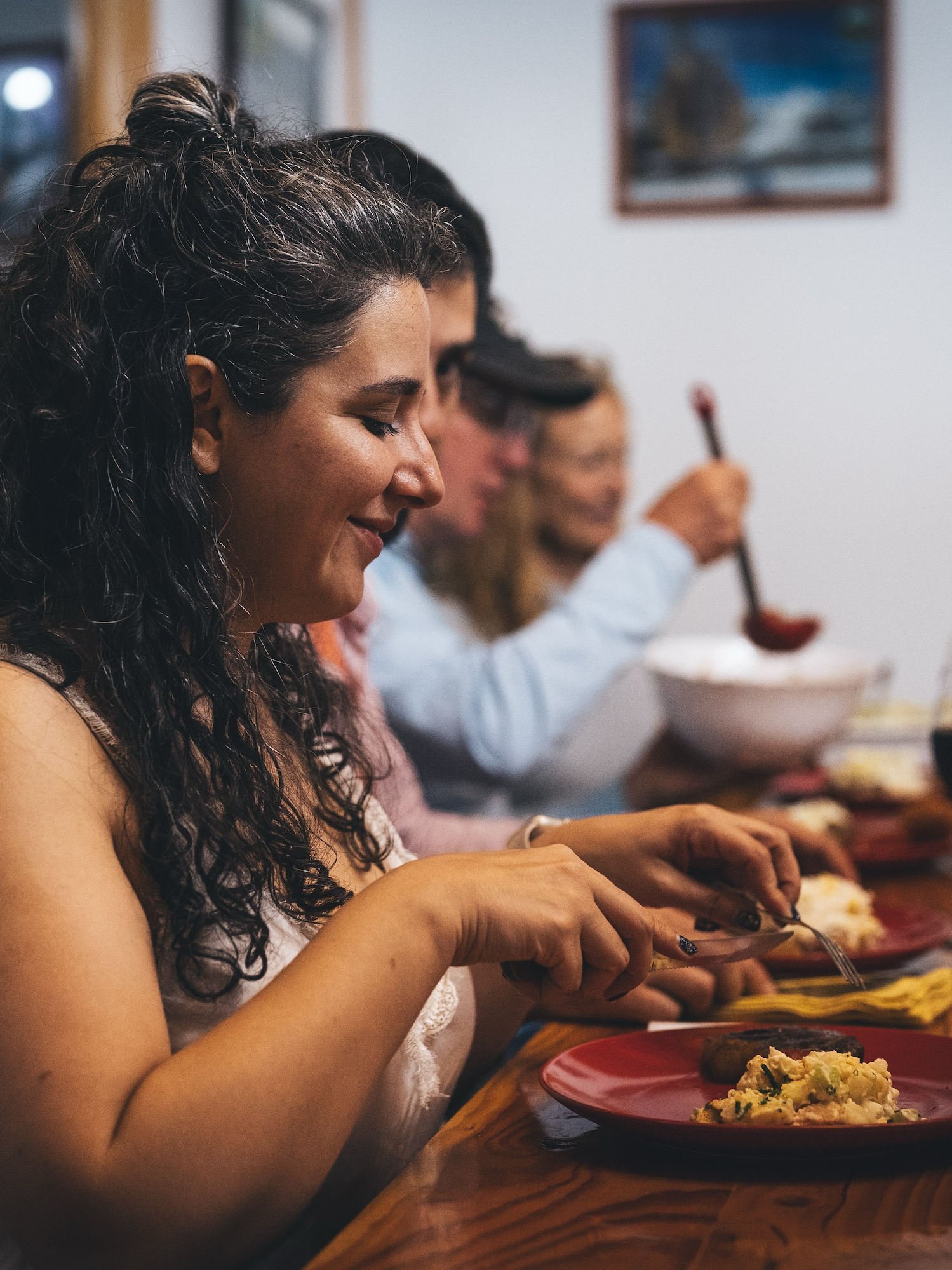 A man in an orange boat casts a fishing line while another person sits behind him