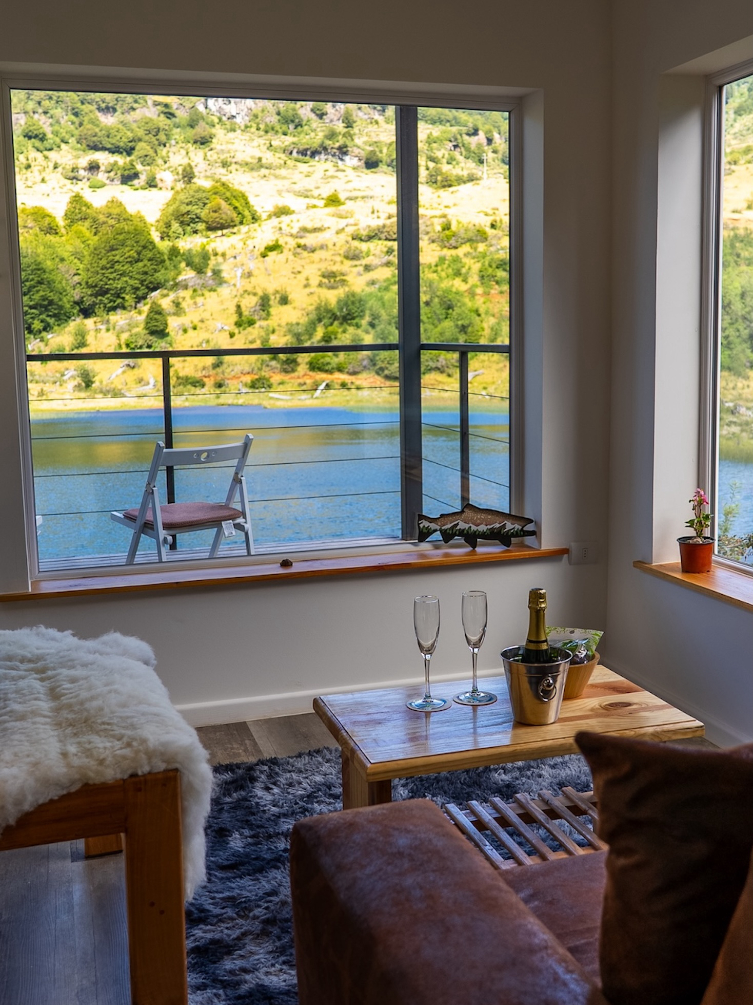 Champagne chills on a coffee table in a seating nook overlooking a placid outdoor landscape